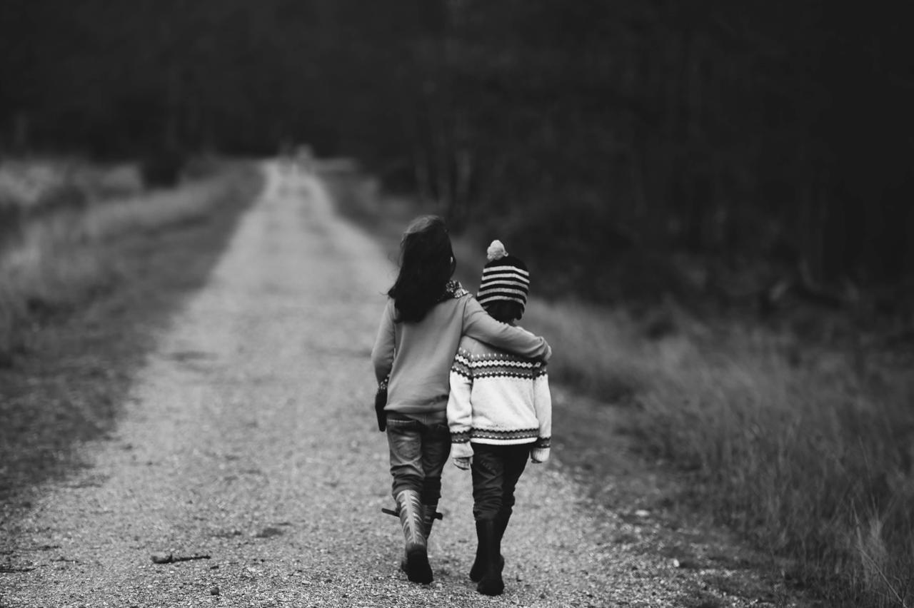 Kids by Annie Spratt Unsplash Two kids walking down a road in grey scale